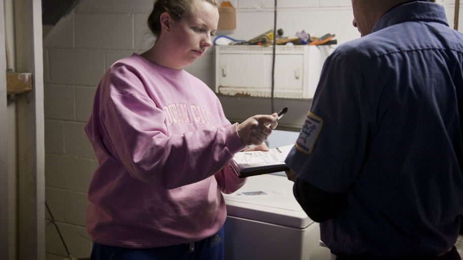 a woman signs a receipt for appliance repair